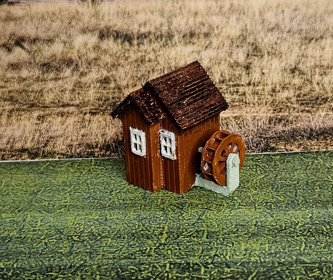 Angled view of N scale waterwheel with medium building